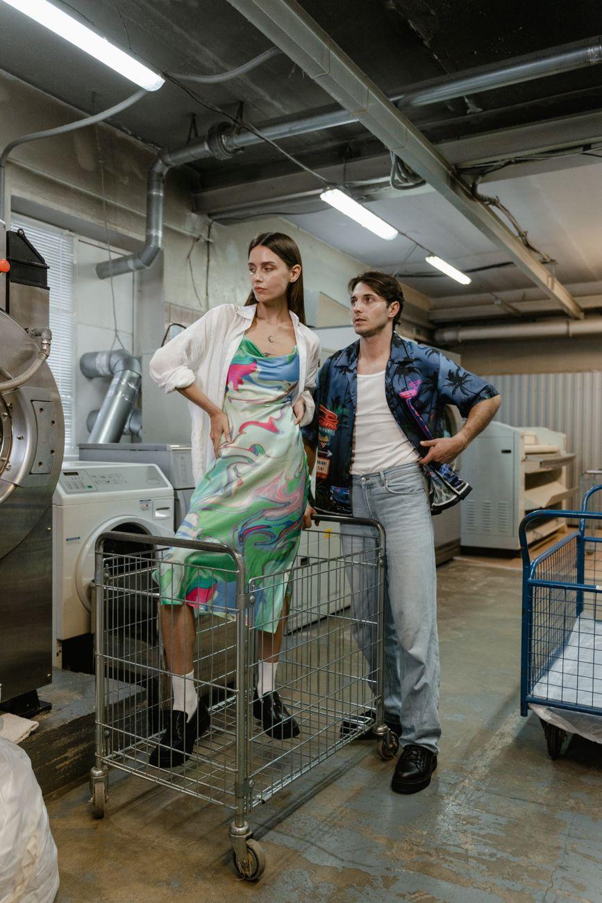 Stylish young adults pose in an industrial laundry. Trendy and artistic ambiance.