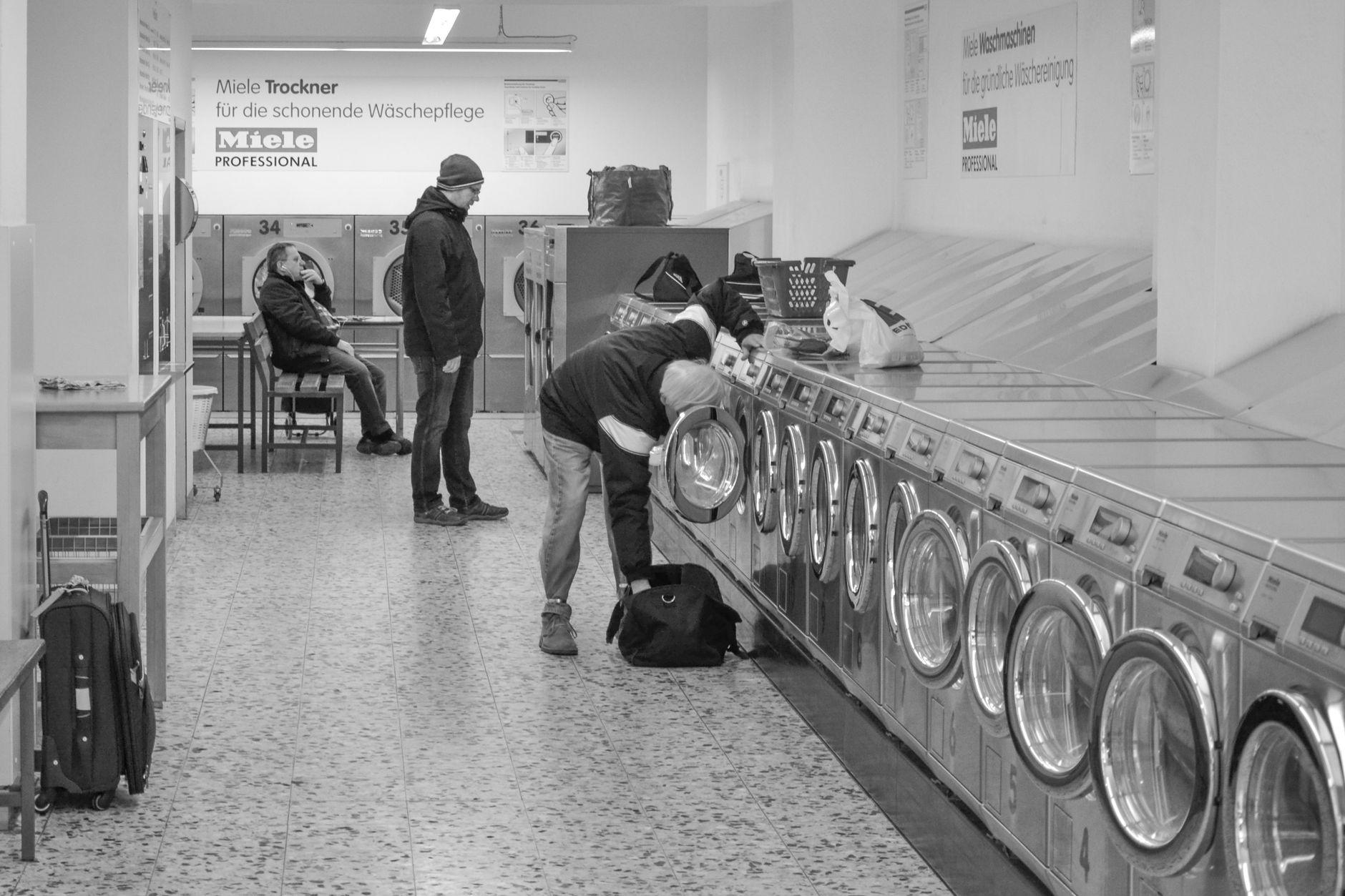 Laundromat interior with people using washing machines, Berlin.